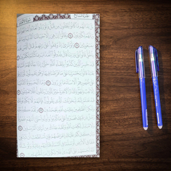 صفحة مظللة من المصحف والقلمين جنبها